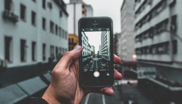 Man taking a photo of buildings by his phone