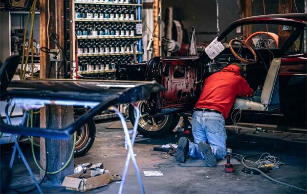 person in garage fixing car