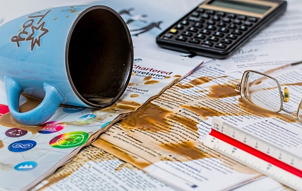 cup of coffee spill in papers